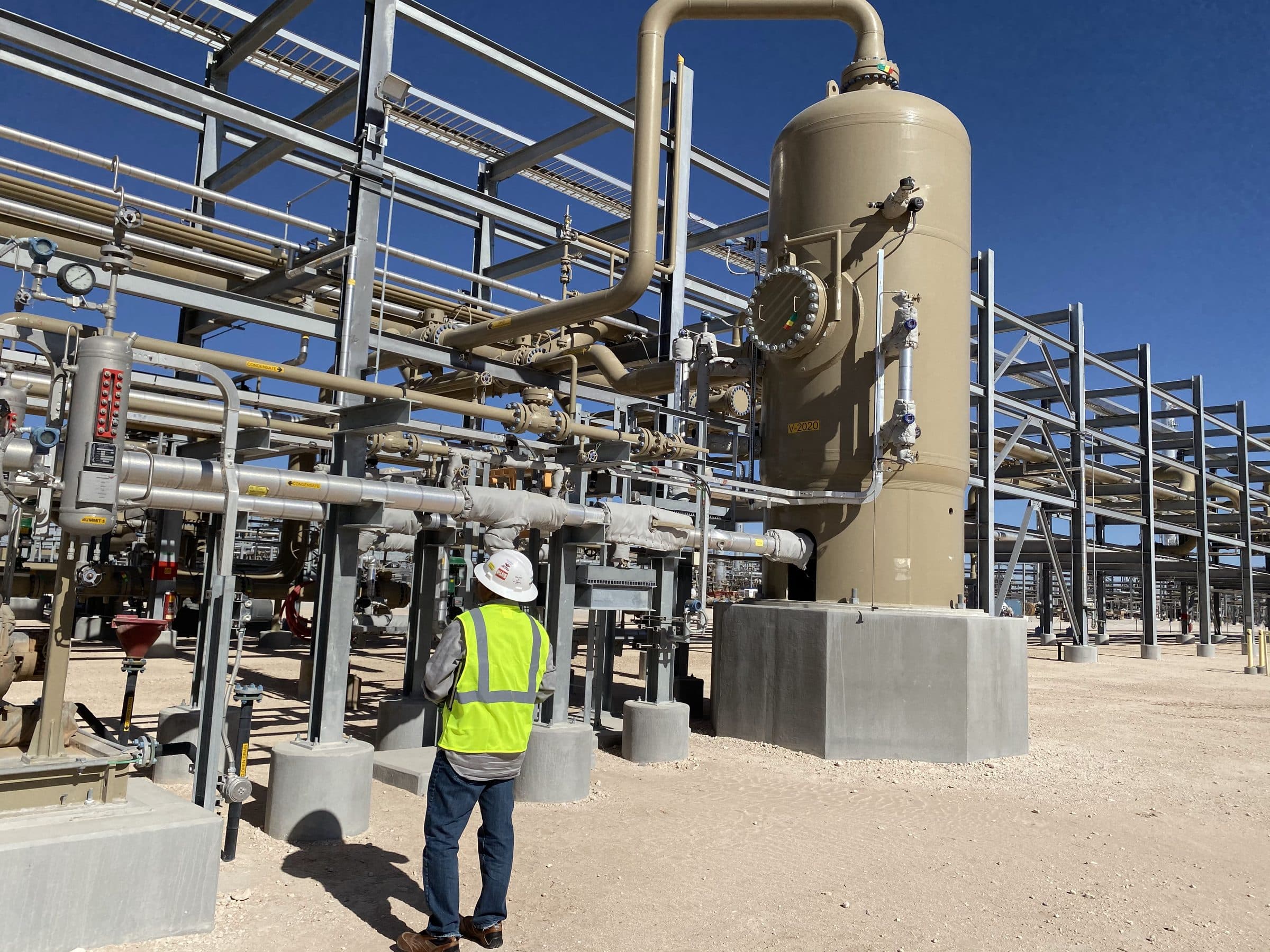 Process plant operator inspecting instrumentation and piping at an industrial manufacturing facility